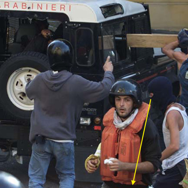 A CARABINIERE POINTS A GUN AS PROTESTERS ATTACK THEIR VEHICLE